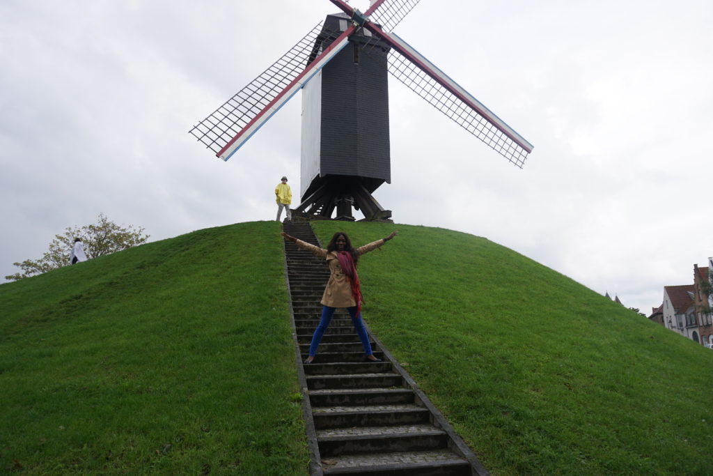 Woman standing in front of a windmill in Bruges
