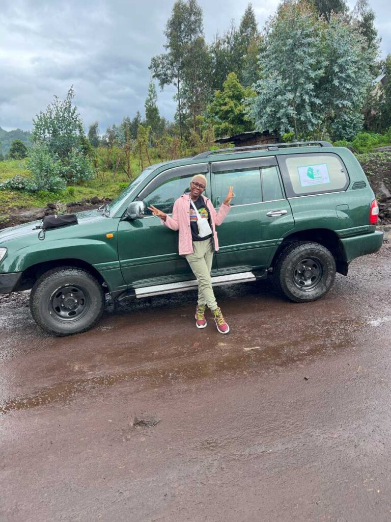 A woman taking a jeep safari to get to Volcanoes National Park for a one day gorilla trekking