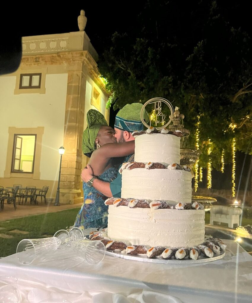 The bride and groom with the wedding cake at a Yoruba wedding at Sicily for a planned destination wedding