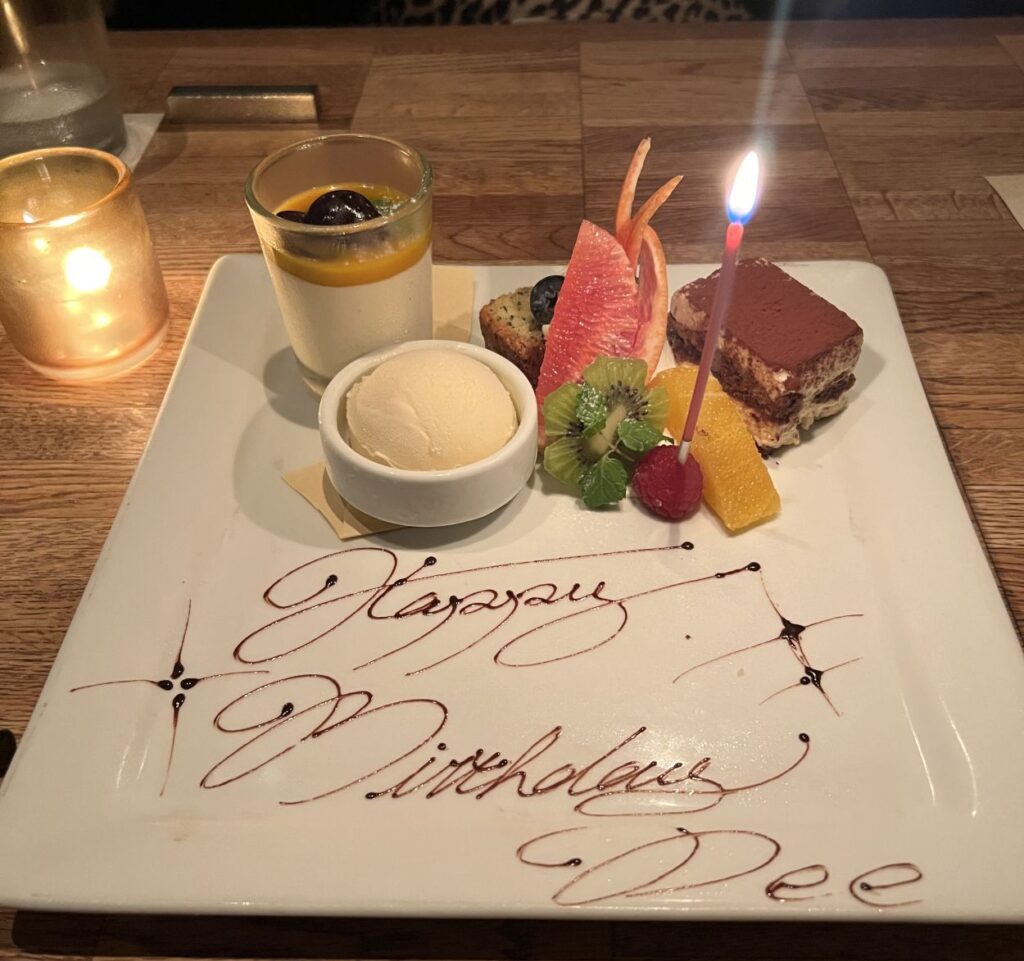 Dee's birthday dinner with a friend in Tokyo with "Happy Birthday Dee" written across the plate.