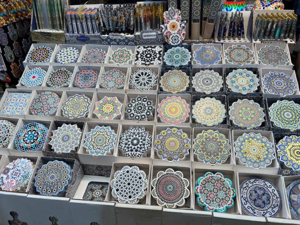 Vibrant ceramic plates stacked in a Marrakech shop filled with Moroccan handicrafts.
