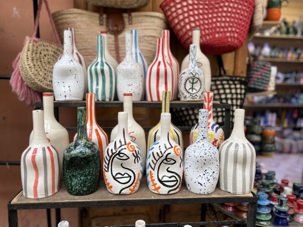 Shopper browsing hand-painted Moroccan pottery in a traditional souk in Marrakech, a popular activity in Marrakech