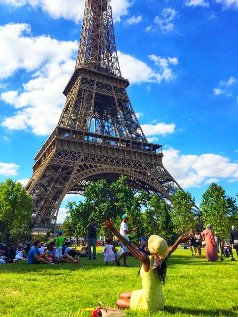 A woman in front of the Eiffel Tower in Paris, showcasing iconic 40th birthday travel ideas