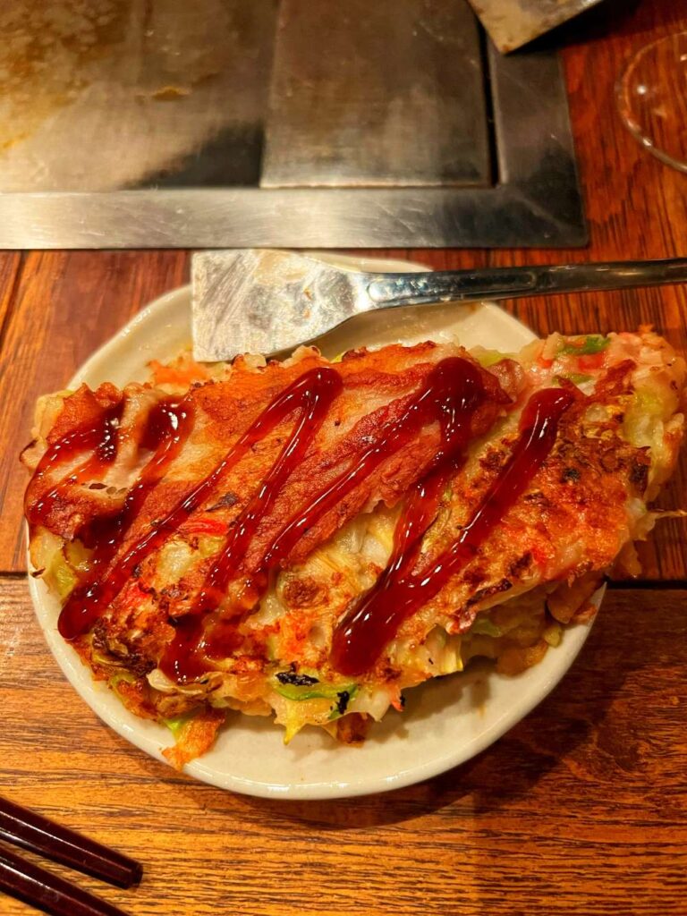 Freshly prepared okonomiyaki served in Japan, capturing flavorful 40th birthday culinary trip ideas