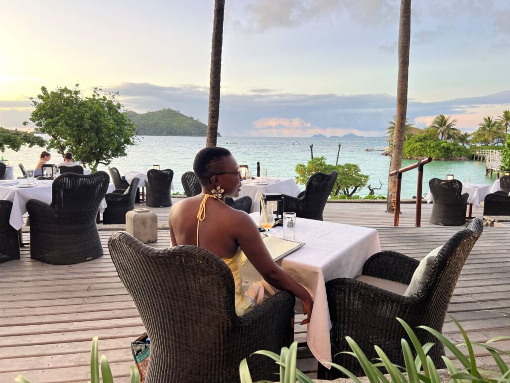A solo woman traveler enjoying a stay amidst breathtaking views at Likuliku Lagoon Resort.